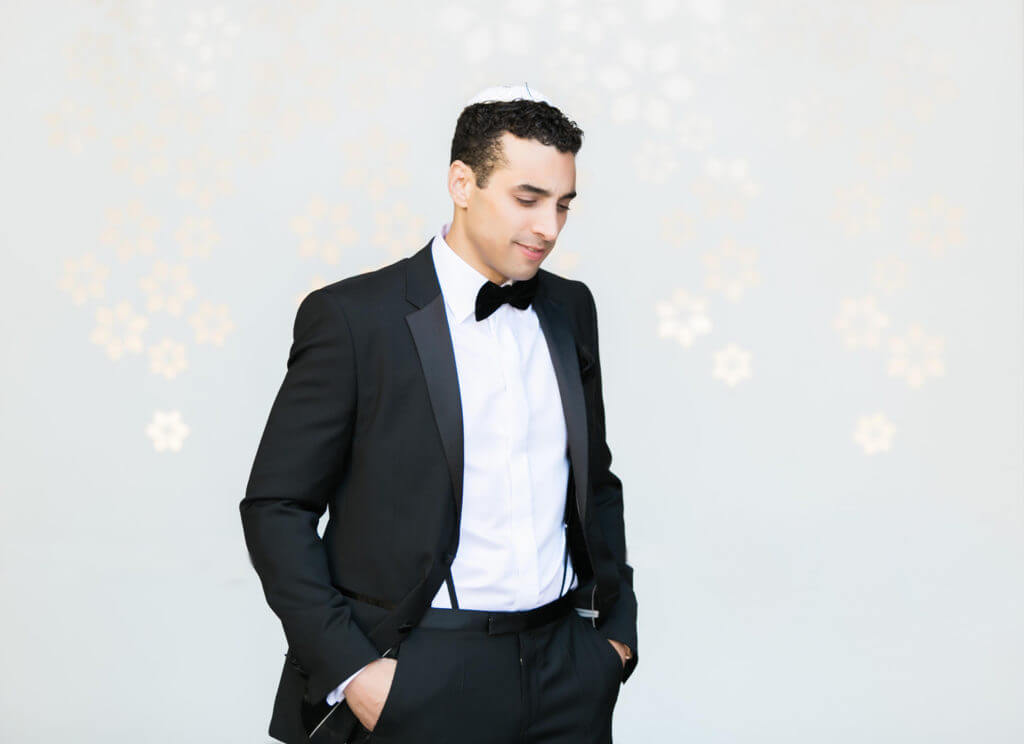 Groom wearing a black Tux with suspenders 