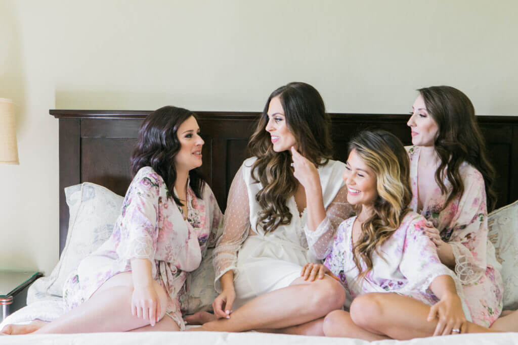 Bridesmaids Wearing pink robes and chatting. 