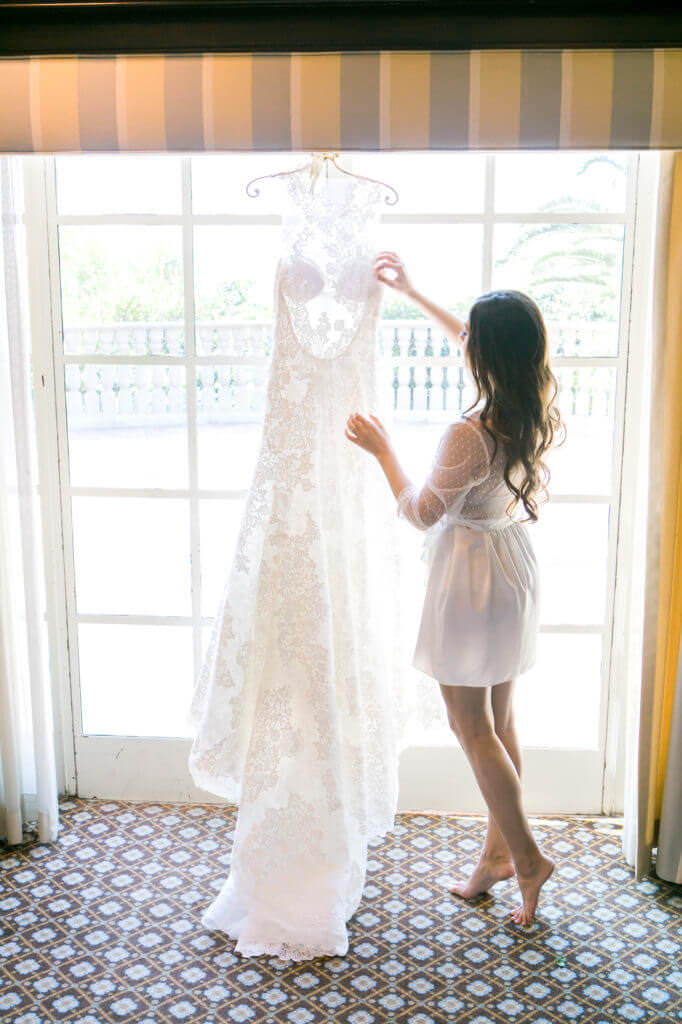 Bride removing dress from the window 