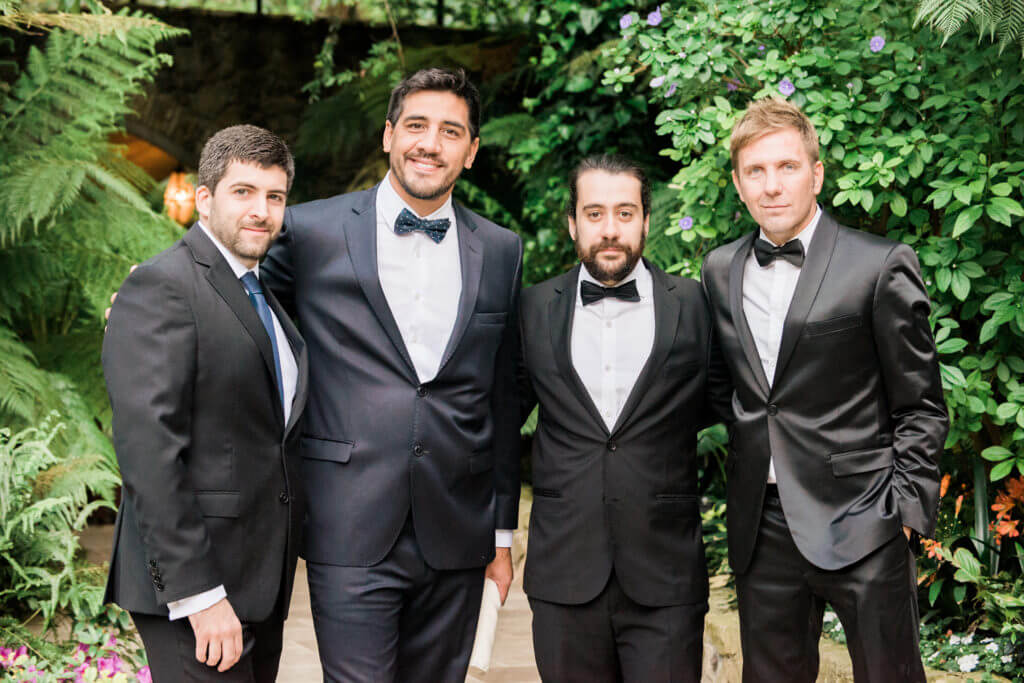 Group of males wearing black tuxedos in a wedding