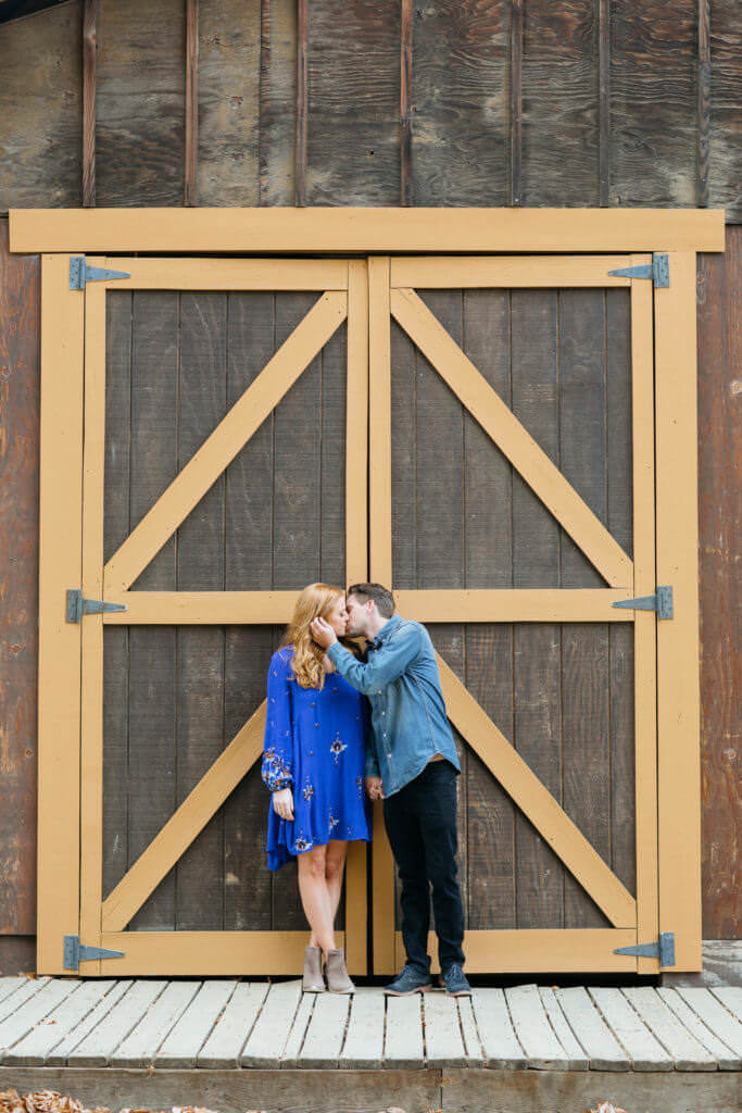 Couple standing next to a barn doors