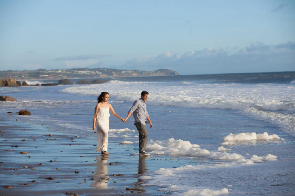 El Matador Beach engagement session couple holding hands 