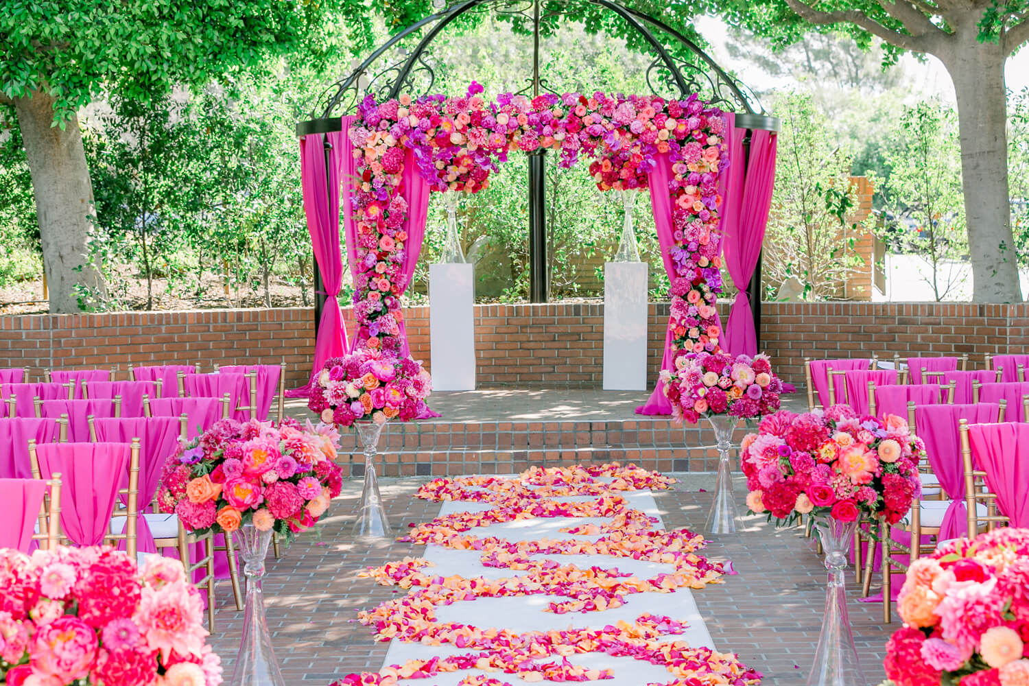 Ceremony site with deep fusia flowers by Bella Vita Events at North Ranch Country Club.