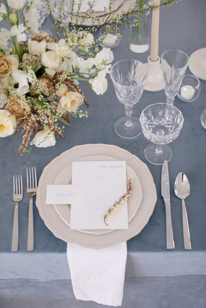 Table setting for a wedding with a blue velvet and a white place