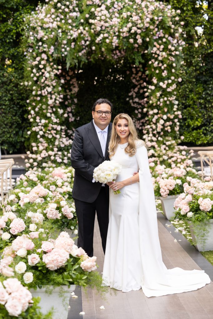 Jewish bride and groom at the Four  Seasons in Beverly Hill next to a Huppah filled with pink roses