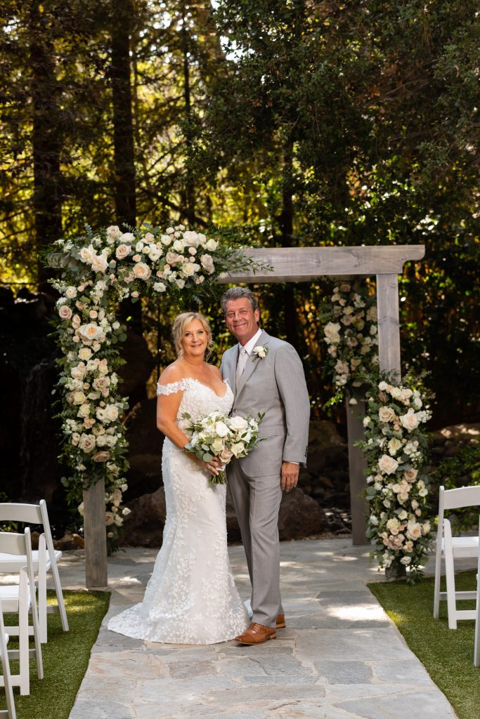 Bride and groom under the huppah at Calamigos ranch florals made by bell of the ball designs