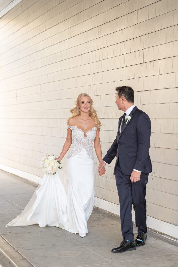 Bride and groom walking on the sidewalk at Shutter on the Beach in Santa Monica