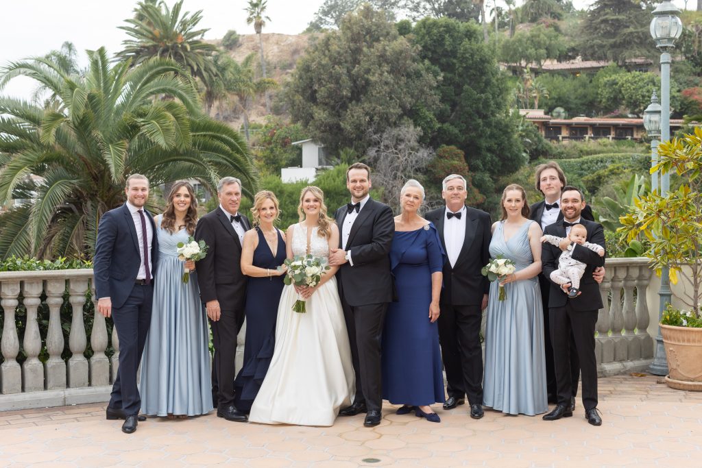 families posing with a bride and groom