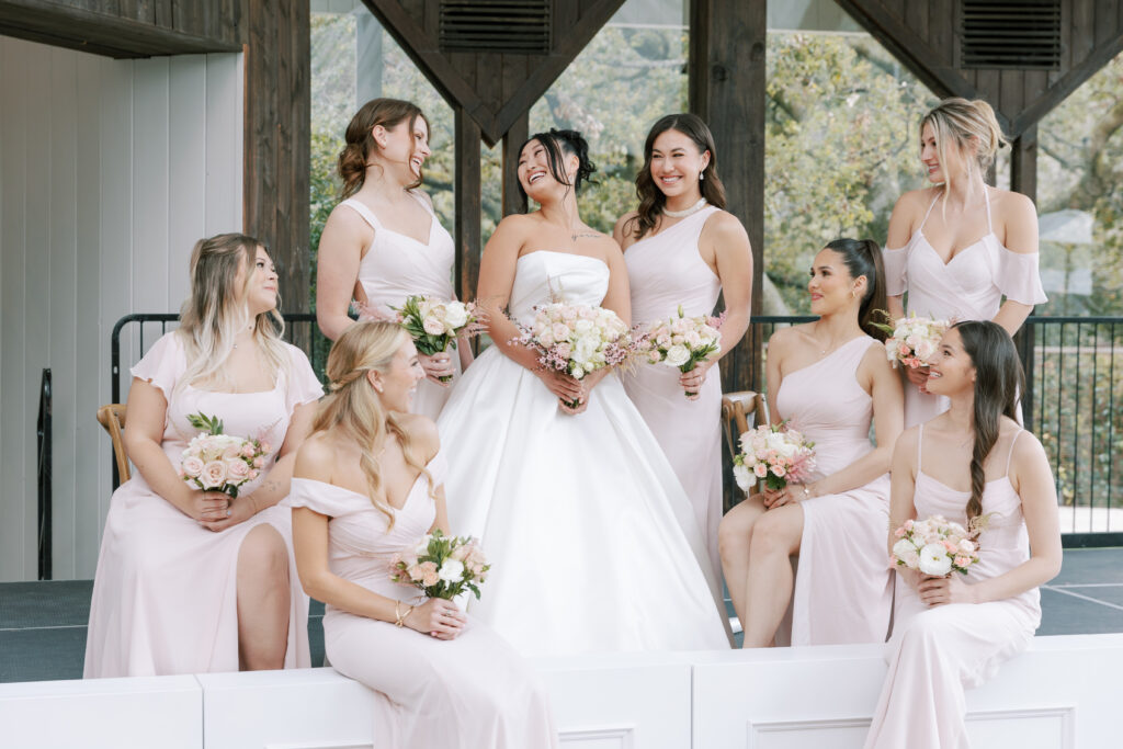Bride and bridesmaids wearing soft pink holding a bridal bouquet in Calamigos Ranch.