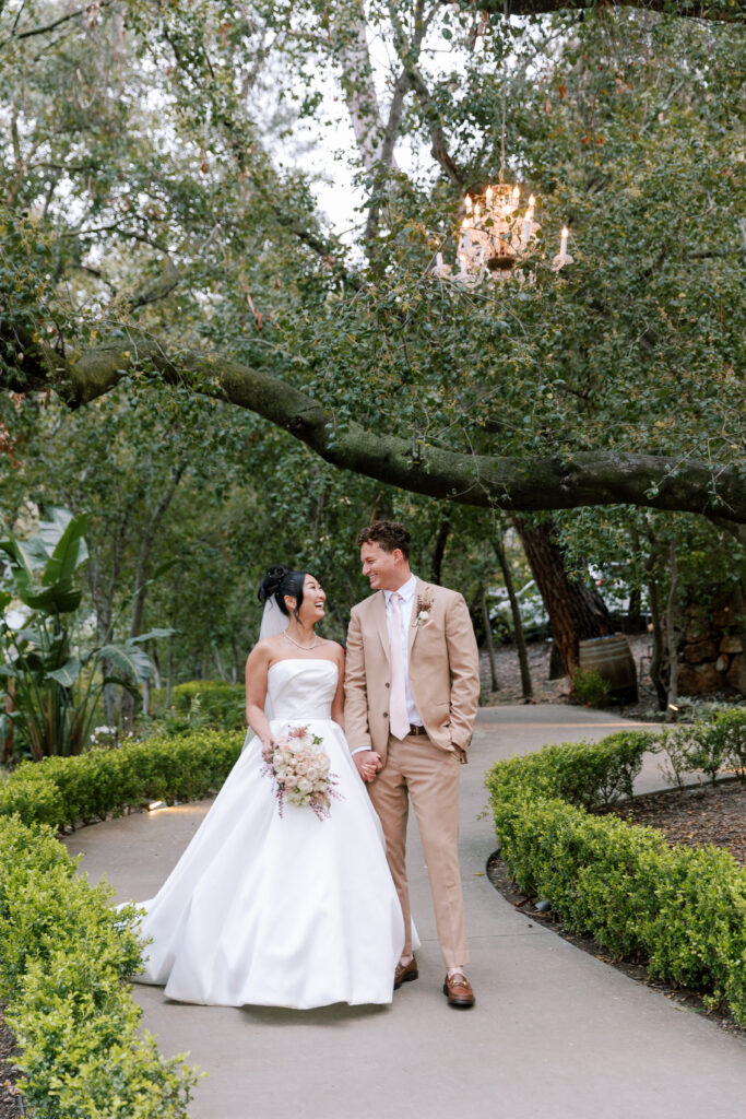 Bride and groom walking on the lush gardesn of the Oak Room at Calamigos Ranch