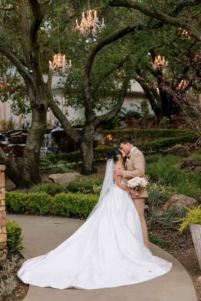 Bride and groom kissing at the lush gardens at Calamigos Oak Room