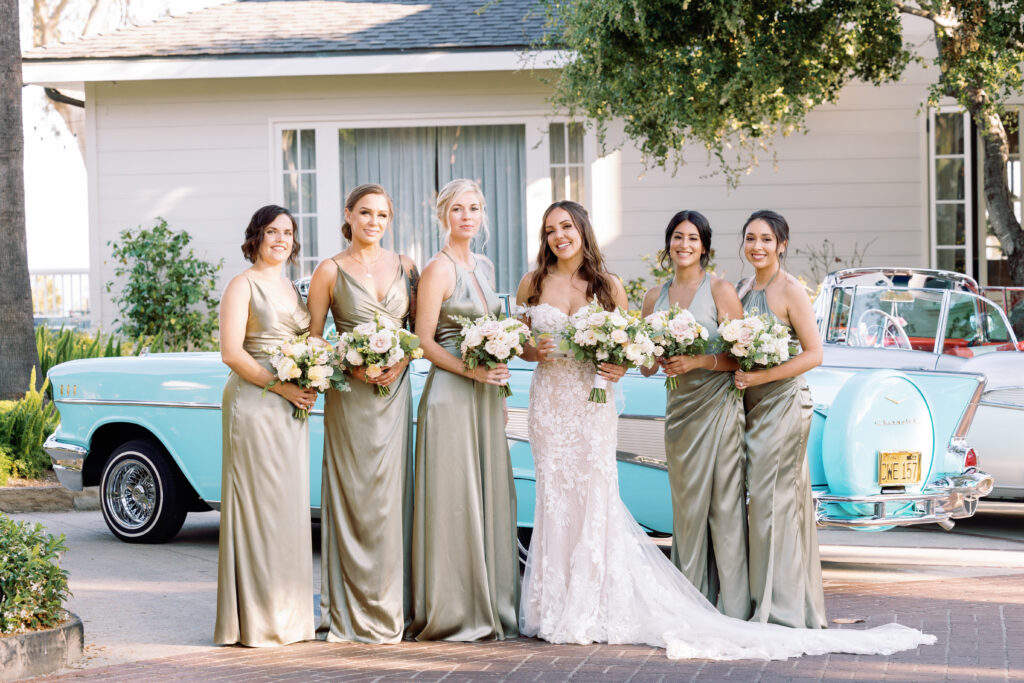 Bridesmaids wearing a sage green dress holding a bridal bouquet