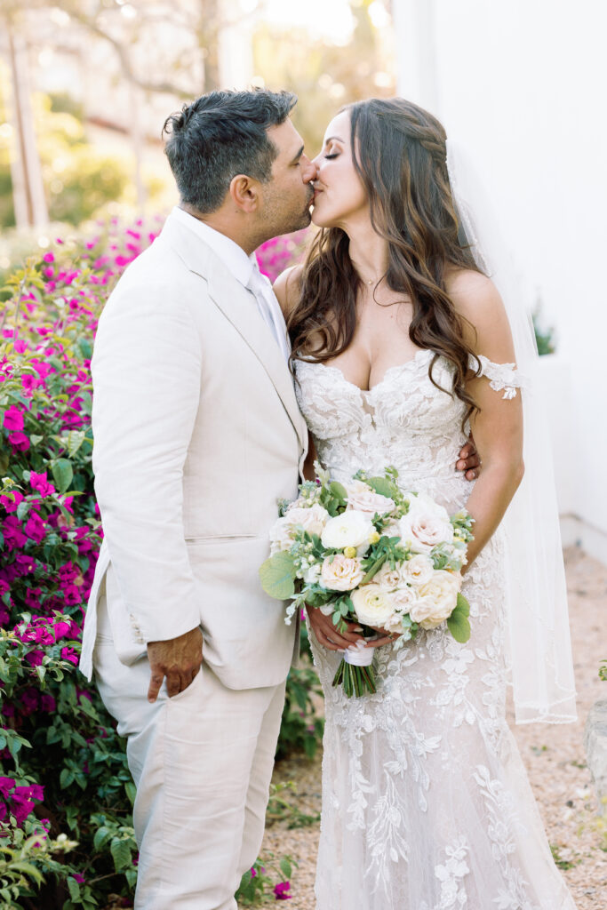 groom wearing a tan color suite kissing a bride at El Encanto en Santa Barbara