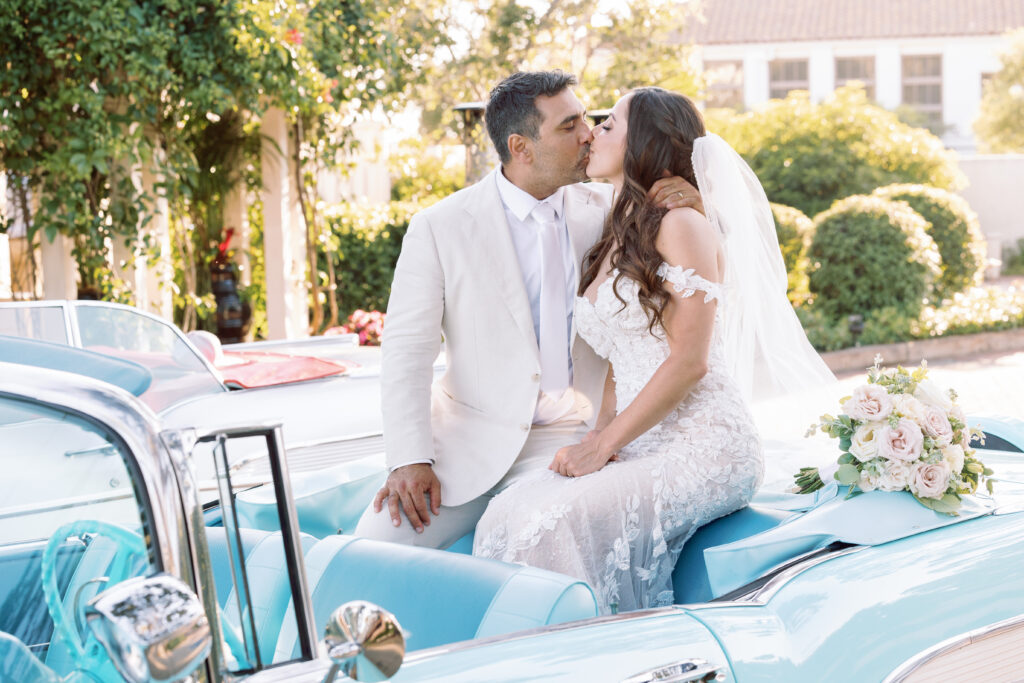 Bride and groom kissing on a convertible in Santa Barbara