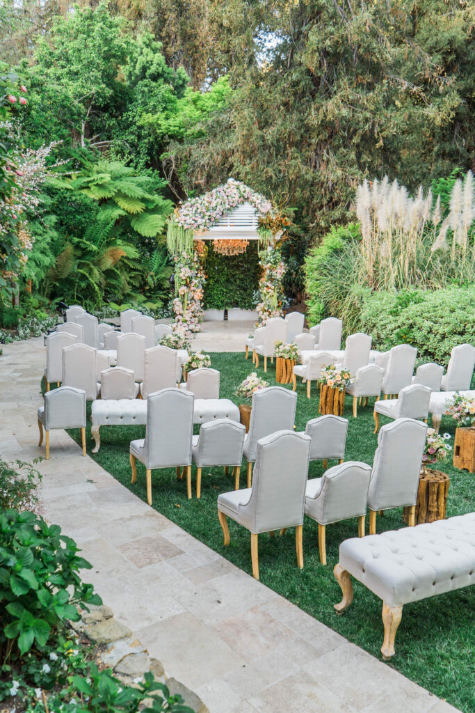 ceremony site with white covered chairs and a Huppah filled with roses at Hotel Bel Air 