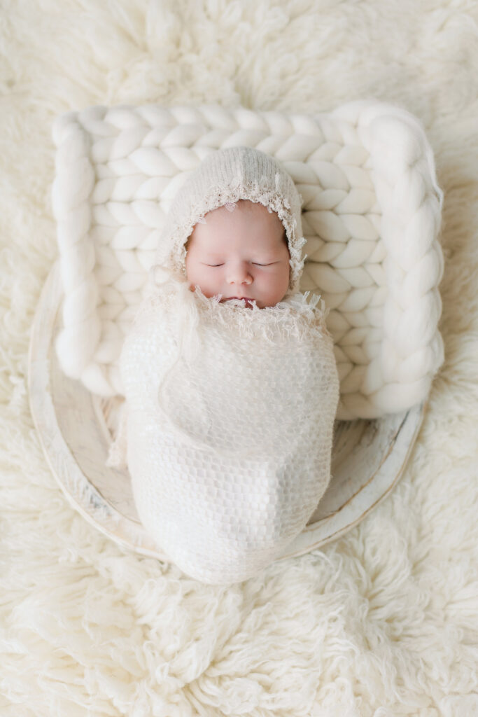 Newborn baby girl wrapped on white fabric