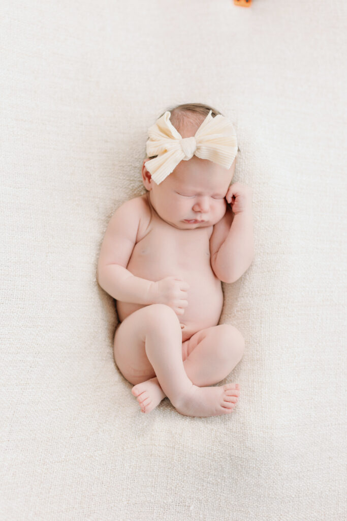 Seven old baby with a cream bow 