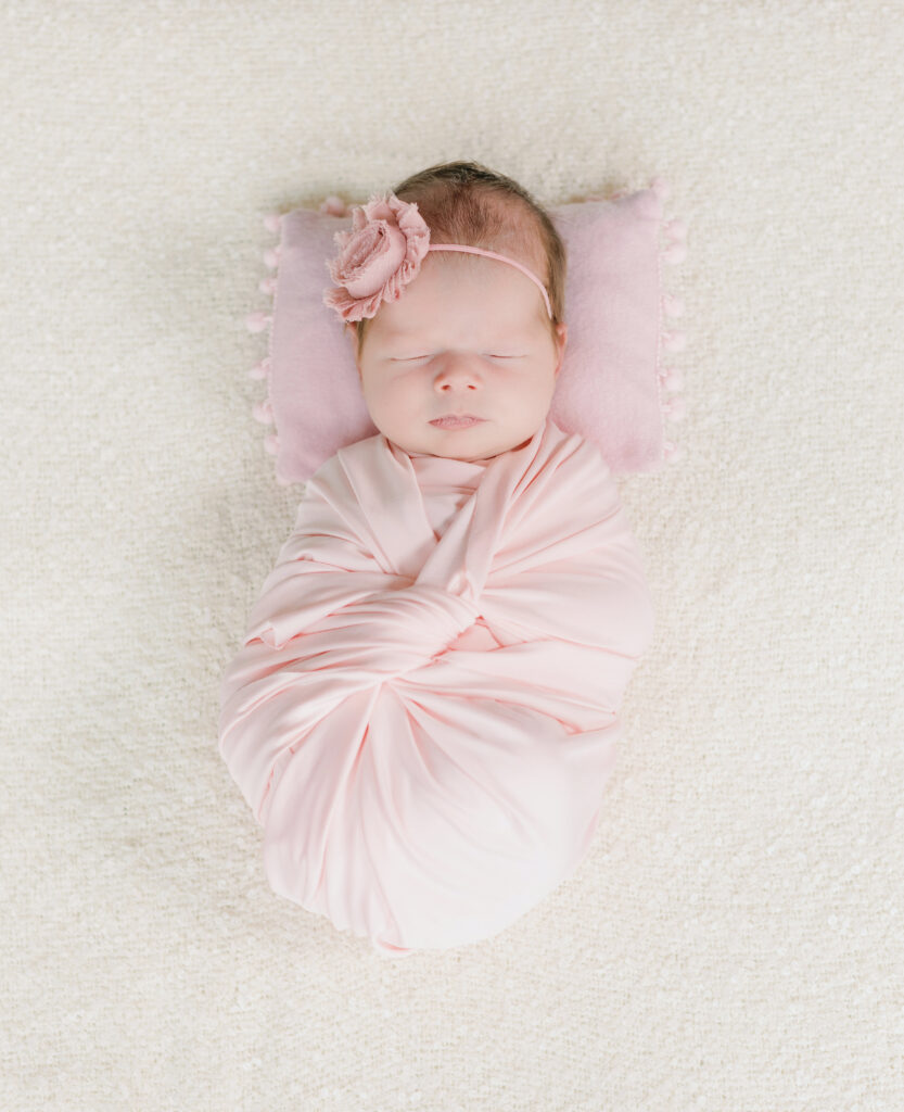 Newborn baby girl cover on a pink drape