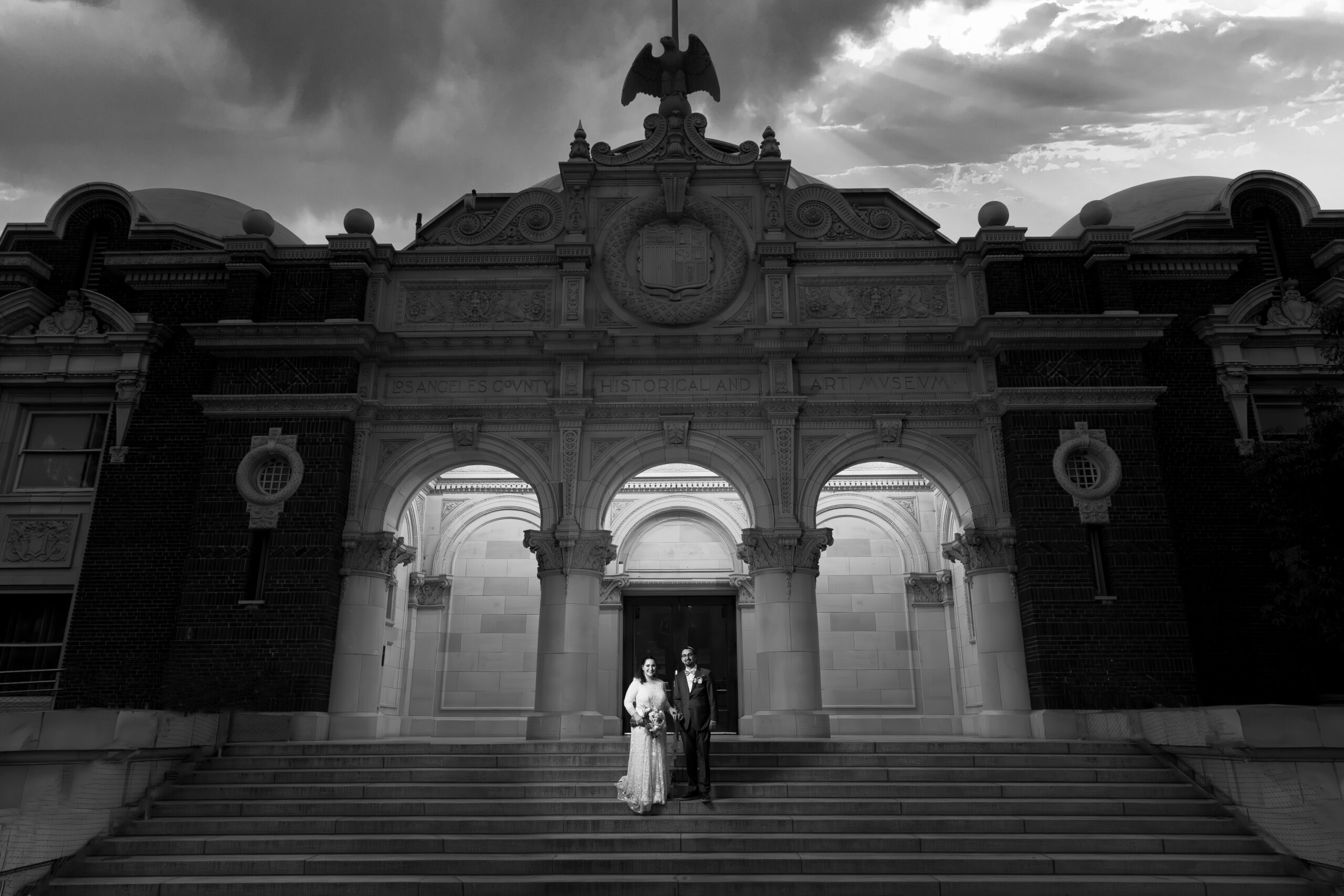 A couple standing on the steps of the Natural History Museum