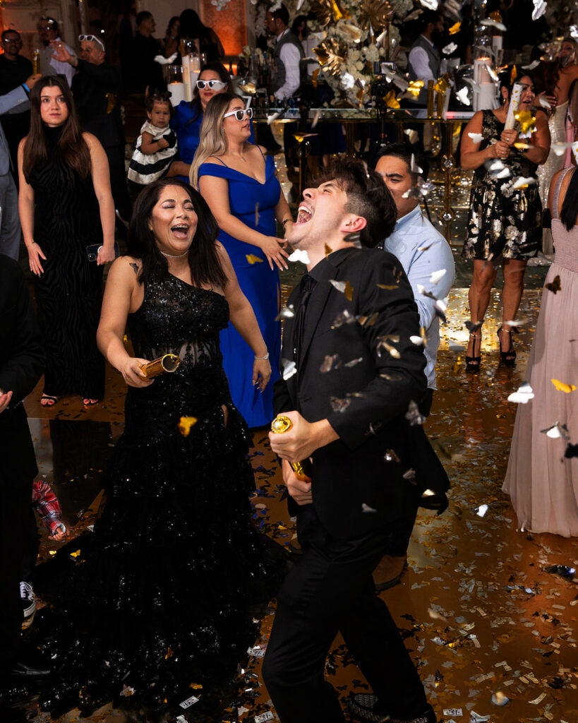 Graduation party at Four Seasons Los Angeles, people dancing with gold confetti drooping from the ceiling. 