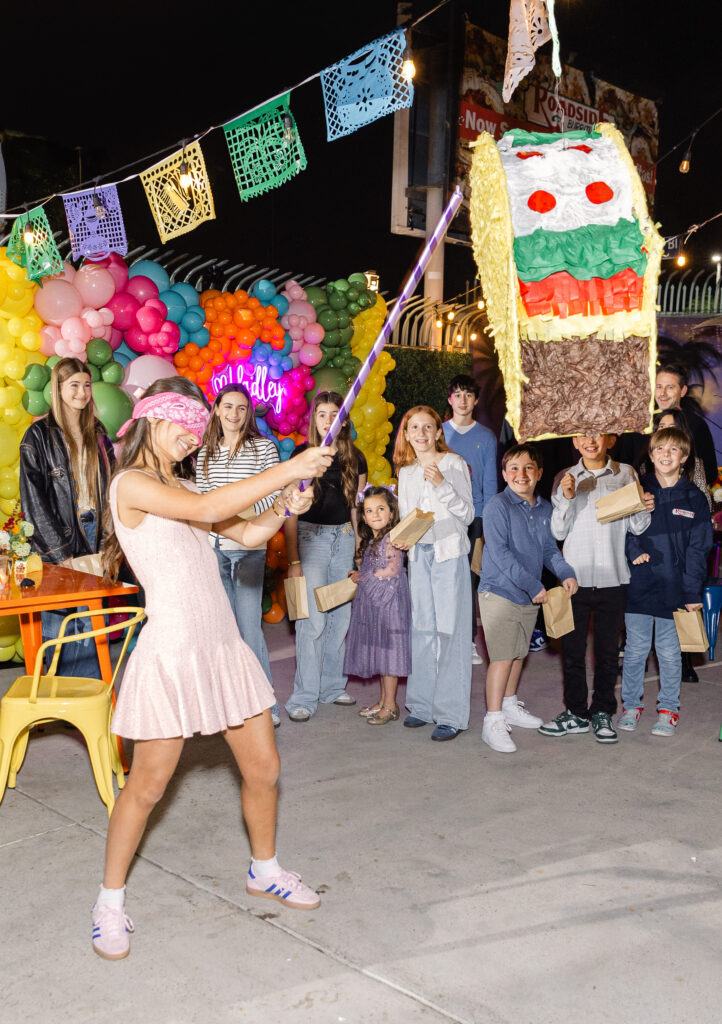 Pre-party fiesta a young Bat Mitzvah breaking the pinata