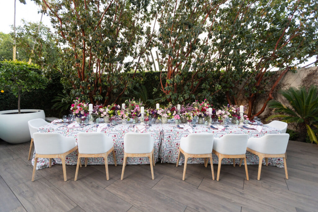 Outdoor editorial wedding tablescape at Waldorf Astoria Beverly Hills with colorful florals, patterned linens, white chairs, and garden greenery.