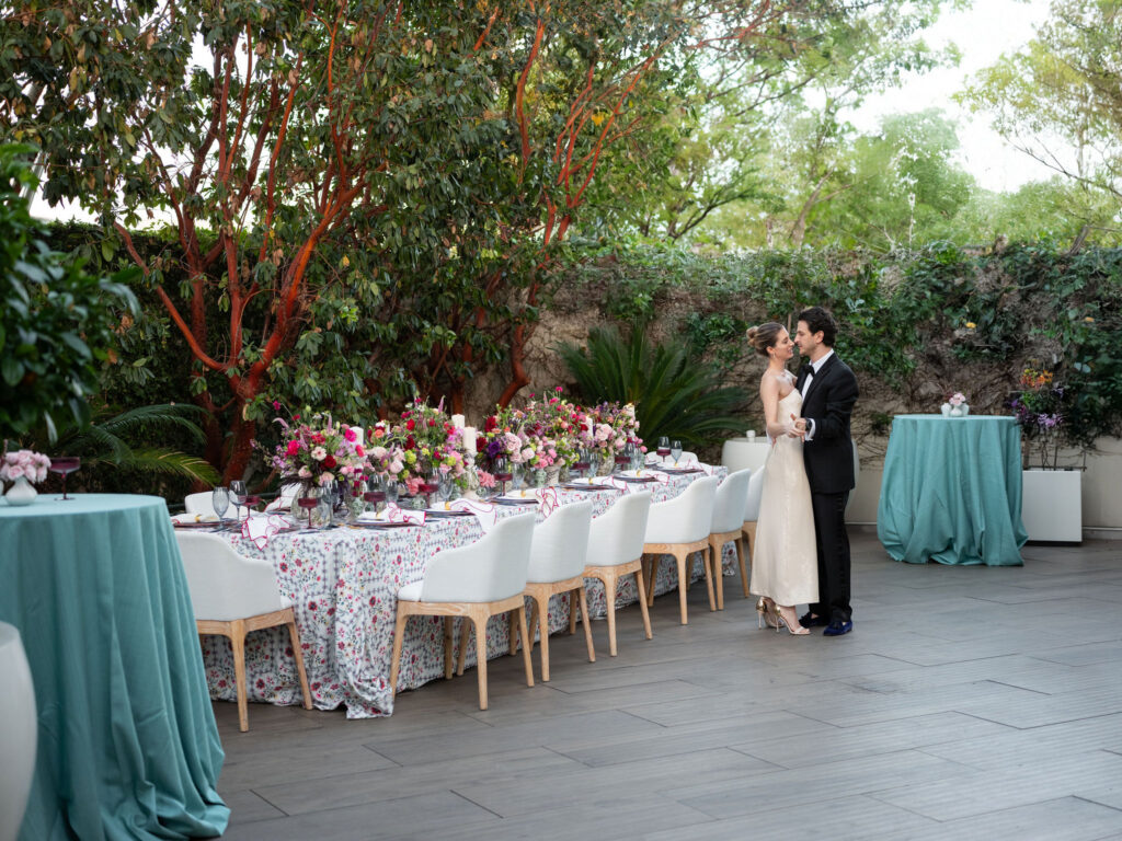 Tablescape at Waldorf Astoria Beverly Hills with colorful florals, patterned linens, white chairs