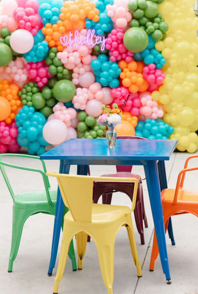 Colorful tables, metal chairs, and a balloon backdrop at an Encino Bat Mitzvah fiesta