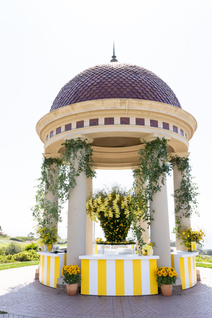 Pelican Hill rotunda transformed into a striped bar with a yellow orchid and lemon centerpiece by The Empty Vase