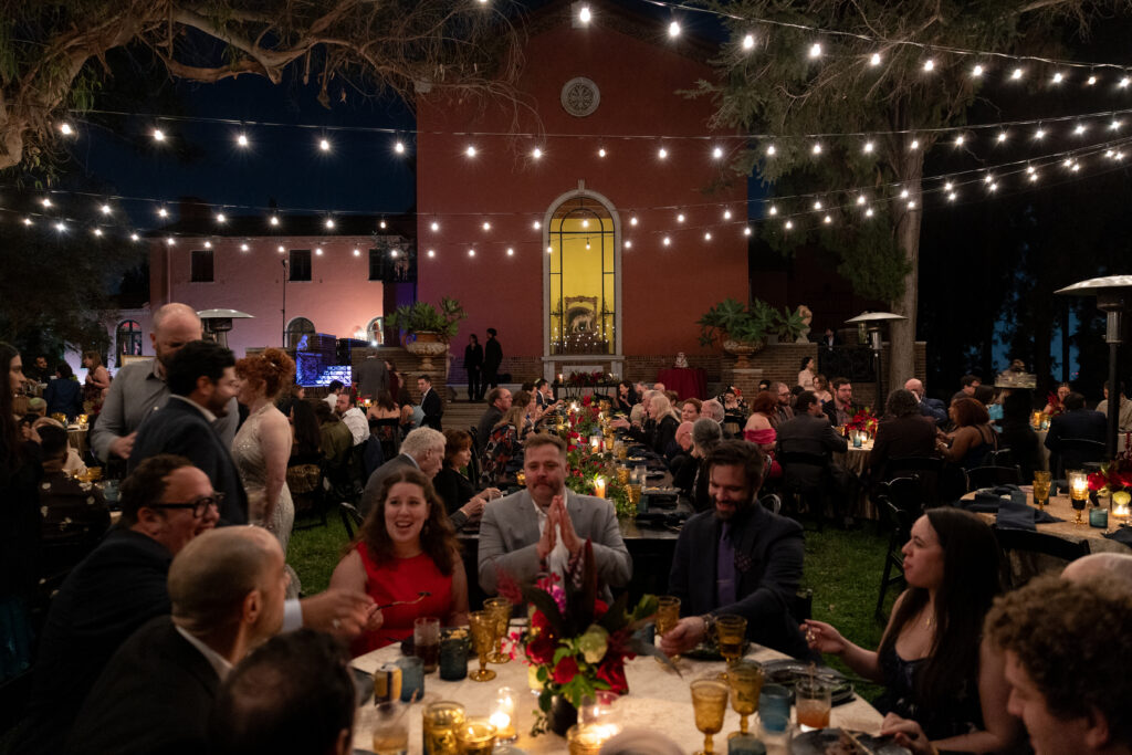 Guests enjoying dinner beneath glowing string lights during the outdoor Paramour Estate reception